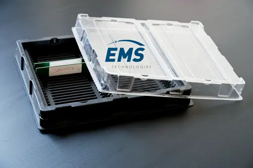Black HIPS slotted ESD tray of boards beside the clear PET lid that closes it, EMS Technologies